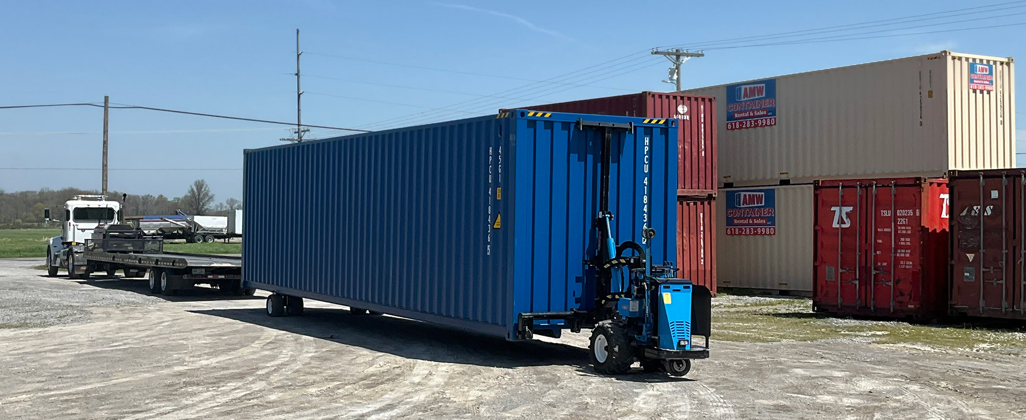 Blue motorized mule pulling container into position.