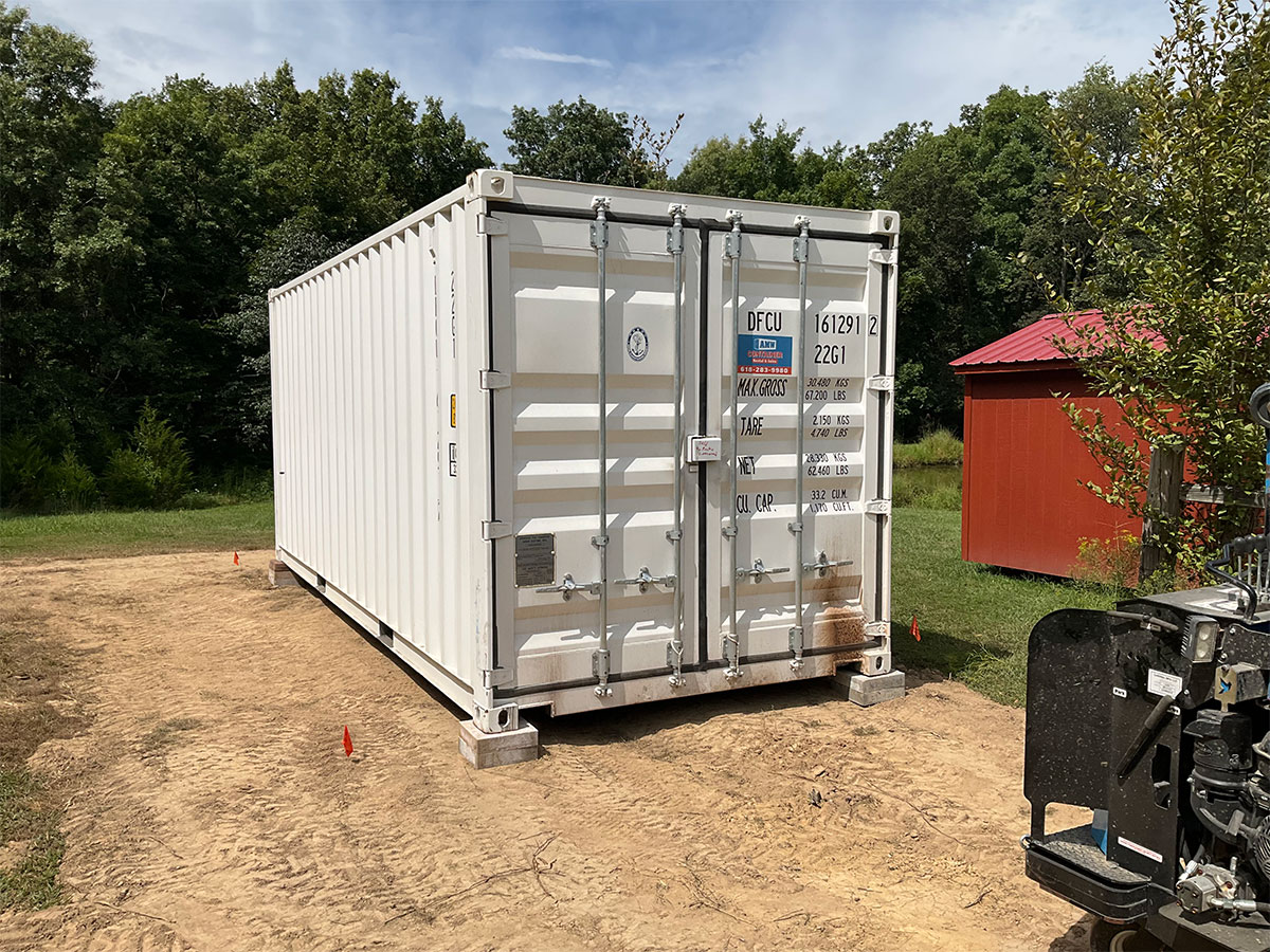 White storage container rental set on blocks at a residential property for convenient onsite storage